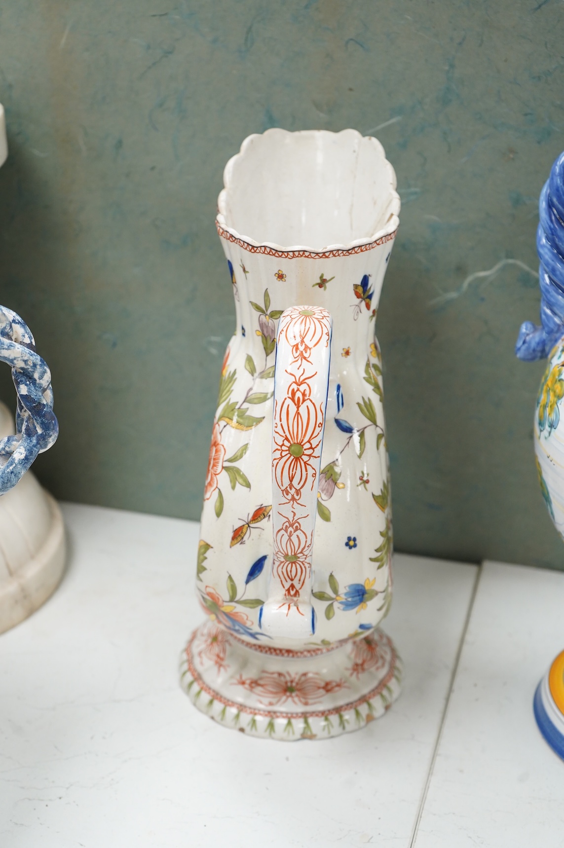 Two large French faience jugs and a vase, and a Talavera twin handled urn/vase, 44cm high